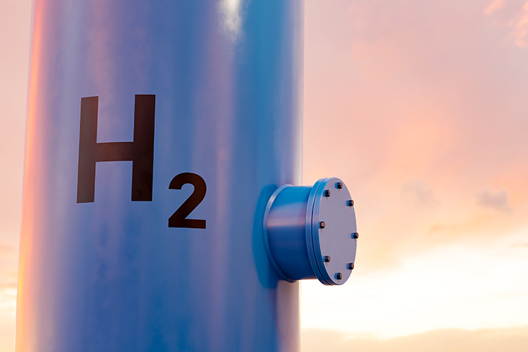 Metallischer Wasserstoffspeicher mit H₂-Kennzeichnung vor hellem Himmel als Symbol für erneuerbare Energien und Wasserstofftechnologie.